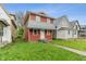 Two-story home with red siding and a metal awning-style roof over the front porch at 2935 Highland Pl, Indianapolis, IN 46208