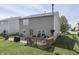 Backyard view featuring a concrete patio, wooden deck, and ample green space with a black fence at 3189 Underwood Dr, Whiteland, IN 46184