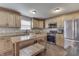 Spacious kitchen with stainless steel appliances, wooden cabinets, granite countertops, and a wooden kitchen island at 3189 Underwood Dr, Whiteland, IN 46184