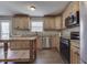 Well-lit kitchen with stainless steel appliances, wood cabinets, granite countertops, and a wooden kitchen island at 3189 Underwood Dr, Whiteland, IN 46184