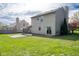 The back of the house with a large patio area, sliding door, and grassy yard at 3611 Owster Ln, Indianapolis, IN 46237