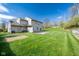 Large backyard featuring an established lawn, mature trees, and a concrete patio area at 3611 Owster Ln, Indianapolis, IN 46237
