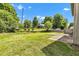 Green backyard with a well-maintained lawn, a patio, a cozy shed, and mature trees at 3611 Owster Ln, Indianapolis, IN 46237