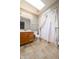 Bathroom with neutral tile flooring, oak vanity, and a shower with skylight at 3611 Owster Ln, Indianapolis, IN 46237