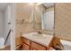 Small well-lit bathroom featuring a vanity with storage, a mirror, and patterned wallpaper at 3611 Owster Ln, Indianapolis, IN 46237