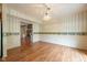 A dining room with wood floors featuring decorative wallpaper and view of the Gathering room at 3611 Owster Ln, Indianapolis, IN 46237