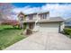 Inviting two-story home with a two-car garage, mature trees, and landscaped front yard at 3611 Owster Ln, Indianapolis, IN 46237