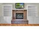 Cozy brick fireplace with built-in shelving, creating a focal point in the living space at 3611 Owster Ln, Indianapolis, IN 46237
