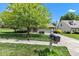 Charming home features a well-manicured lawn, mature tree, and inviting curb appeal on a sunny day at 3611 Owster Ln, Indianapolis, IN 46237