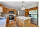 Kitchen featuring stainless steel appliances, an island, and oak cabinetry at 3611 Owster Ln, Indianapolis, IN 46237