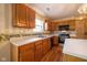 This kitchen has wooden cabinets, a tiled backsplash, stainless steel appliances, and hardwood floors at 3611 Owster Ln, Indianapolis, IN 46237