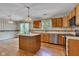 Bright eat-in kitchen showcasing an island, oak cabinetry, and a window overlooking the yard at 3611 Owster Ln, Indianapolis, IN 46237
