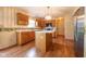 This kitchen features wooden cabinets, a center island, stainless steel appliances, and hardwood floors at 3611 Owster Ln, Indianapolis, IN 46237