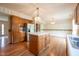 This kitchen has wooden cabinets, a center island, stainless steel appliances, and hardwood floors at 3611 Owster Ln, Indianapolis, IN 46237