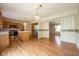 Kitchen with stainless steel appliances, a center island, wooden cabinets, hardwood floors, and stylish lighting at 3611 Owster Ln, Indianapolis, IN 46237