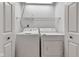 Bright laundry room featuring side by side washer and dryer units, white walls, and open doorway at 3611 Owster Ln, Indianapolis, IN 46237