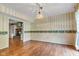 Living room with hardwood floors, striped wallpaper, and a glimpse of a fireplace in the adjoining room at 3611 Owster Ln, Indianapolis, IN 46237