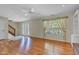 Sunlit living room boasts hardwood floors and a large window, seamlessly connecting to the foyer and staircase at 3611 Owster Ln, Indianapolis, IN 46237