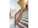 A staircase with hardwood treads and a view into the living room is inviting and spacious at 3611 Owster Ln, Indianapolis, IN 46237