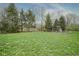 Spacious backyard with manicured lawn and mature trees, offering ample space for outdoor activities at 3837 Penzance Pl, Carmel, IN 46032