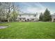 Expansive backyard featuring a beautiful deck, stone patio, and lush lawn at 3837 Penzance Pl, Carmel, IN 46032