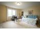Bedroom with large window, daybed with turquoise pillows, and a desk with a chair at 3837 Penzance Pl, Carmel, IN 46032