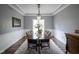 Elegant dining room features a chandelier, large table, and serene view from the bright window at 3837 Penzance Pl, Carmel, IN 46032