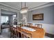 This dining room features an elegant chandelier, a large table and a decorative painting on the wall at 3837 Penzance Pl, Carmel, IN 46032