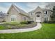 Beautiful brick home with manicured lawn and landscaping leading to an arched entry at 3837 Penzance Pl, Carmel, IN 46032