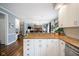 The kitchen with granite countertops, stainless steel appliances, and white cabinets flows into the living space at 3837 Penzance Pl, Carmel, IN 46032