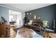 Cozy living room featuring hardwood floors, a leather sofa, and stylish decor at 3837 Penzance Pl, Carmel, IN 46032