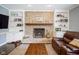 Charming living room featuring a brick fireplace and built-in bookshelves at 3837 Penzance Pl, Carmel, IN 46032