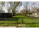 Large fenced backyard featuring a spacious lawn, mature trees, and ample space for outdoor activities at 3909 Aloda St, Indianapolis, IN 46203