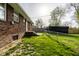 Fenced backyard featuring a brick home, a grassy area, and mature trees at 3909 Aloda St, Indianapolis, IN 46203