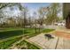 Backyard view with a small patio, a fire pit, a chain link fence, and a large grassy area at 3909 Aloda St, Indianapolis, IN 46203