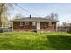 View of the backyard with chain link fence and a brick home at 3909 Aloda St, Indianapolis, IN 46203