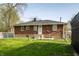 View of the backyard with chain link fence and a brick home at 3909 Aloda St, Indianapolis, IN 46203