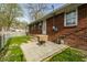 Backyard view with a brick house, small concrete patio, and a fenced yard at 3909 Aloda St, Indianapolis, IN 46203