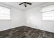 An empty bedroom with a ceiling fan, two windows, and modern flooring at 3909 Aloda St, Indianapolis, IN 46203