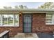 A welcoming front entrance features a brick facade, a security door, and a 'Home' welcome mat at 3909 Aloda St, Indianapolis, IN 46203