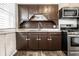 A kitchen featuring dark wood cabinetry, stainless steel appliances, and neutral countertops at 3909 Aloda St, Indianapolis, IN 46203