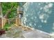 Backyard patio features stone tiles, a wooden fence and stairs, and view of side of house at 401 Sanders St, Indianapolis, IN 46225