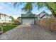 Spacious garage with a modern door and a long driveway leading to the street surrounded by beautiful trees and foliage at 401 Sanders St, Indianapolis, IN 46225