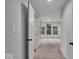 Hallway featuring neutral walls, plush carpet, and an open view into a naturally lit room at 401 Sanders St, Indianapolis, IN 46225