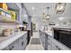 Well-lit kitchen featuring gray cabinetry, stainless appliances, quartz countertops, and decorative pendant lighting at 401 Sanders St, Indianapolis, IN 46225