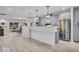 Open-concept living space showcasing hardwood floors, stainless steel appliances, and modern kitchen leading to the dining area at 401 Sanders St, Indianapolis, IN 46225