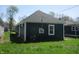 Back view of house featuring dark siding, white trim, a gray roof and a green lawn at 4230 Kingsley Dr, Indianapolis, IN 46205