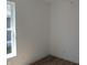 A bedroom is shown with fresh white paint, new flooring and baseboards, and a bright window at 4230 Kingsley Dr, Indianapolis, IN 46205