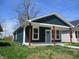Charming home featuring a blue front door, red pillars, and well-maintained lawn at 4230 Kingsley Dr, Indianapolis, IN 46205