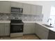 Kitchen features stainless steel appliances, tile backsplash, and white countertops at 4230 Kingsley Dr, Indianapolis, IN 46205
